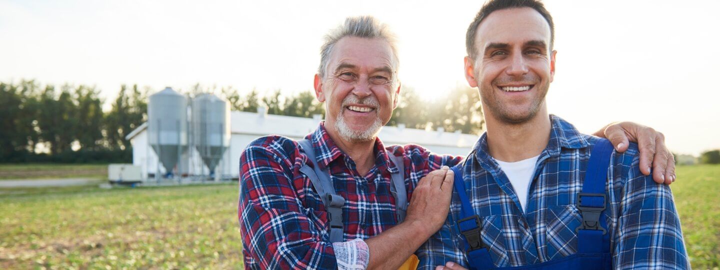 Vater und Sohn stehen auf einem Feld ihres landwirtschaftlichen Betriebs