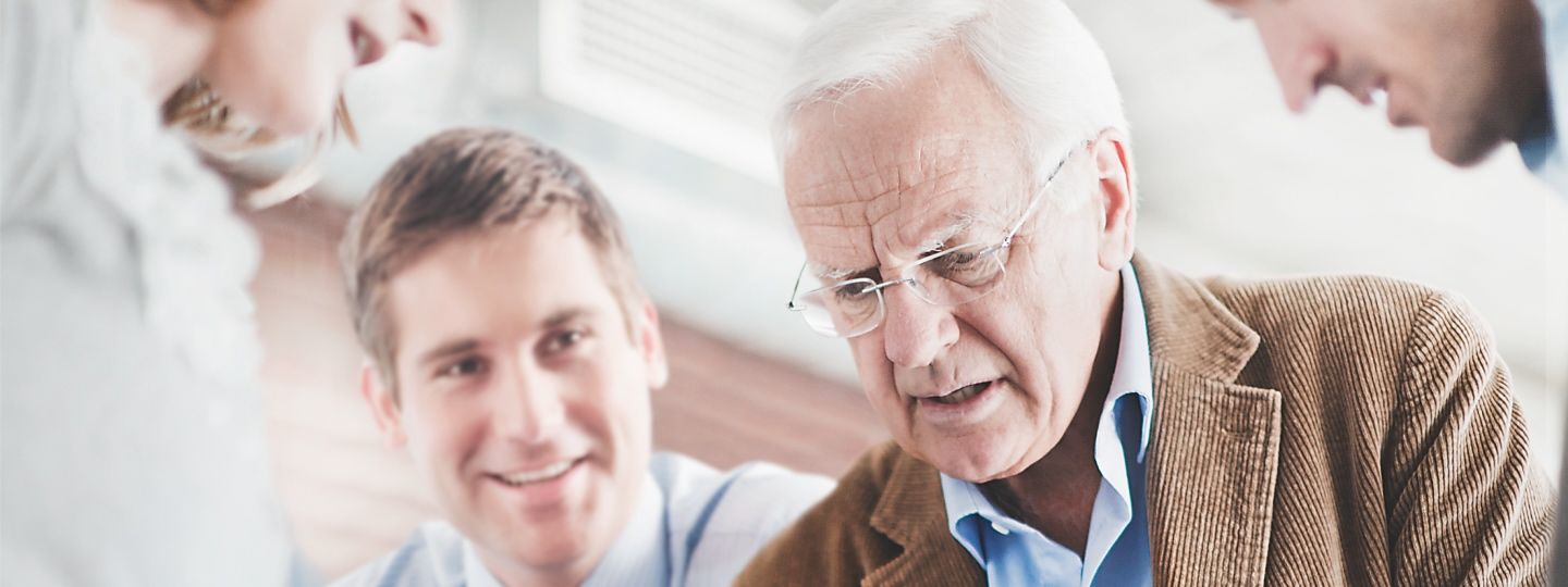Zwei Männer, ein jüngerer und ein älterer sprechen im Büro