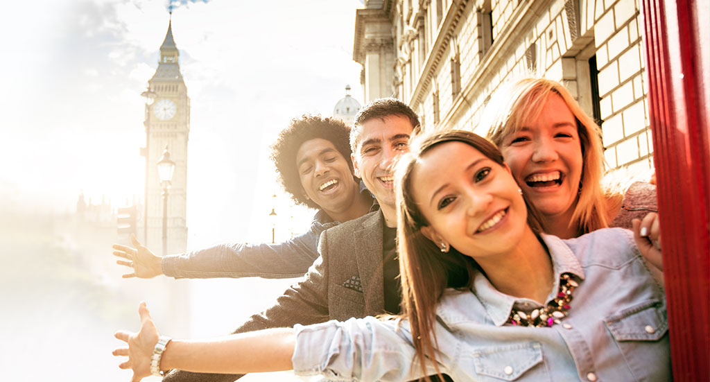 Jugendliche strecken freudig die haende aus und lachen ausland sightseeing auslandskrankenversicherung langzeit